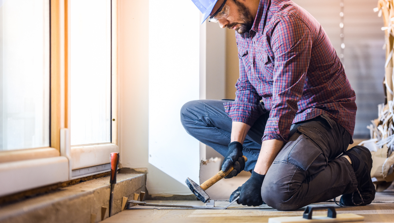 Hardwood floor installation and board work near a sliding glass door