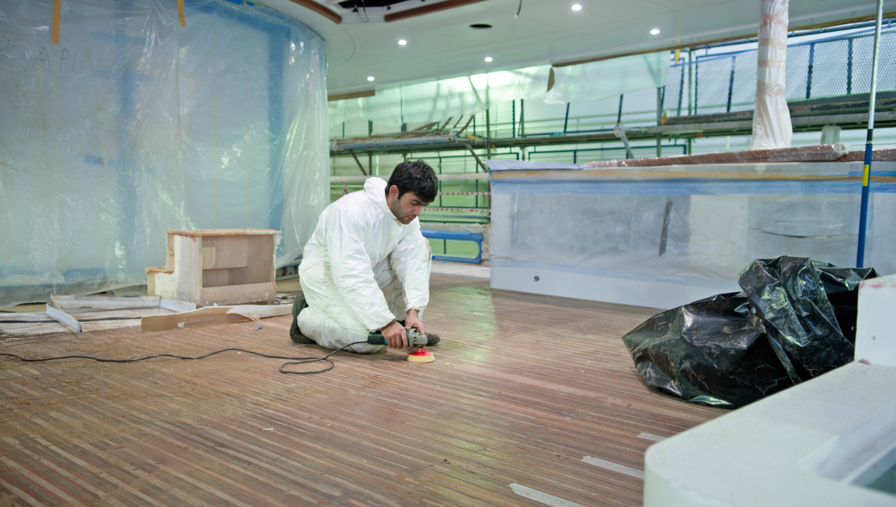 Floor technician buffing and repairing a wood floor