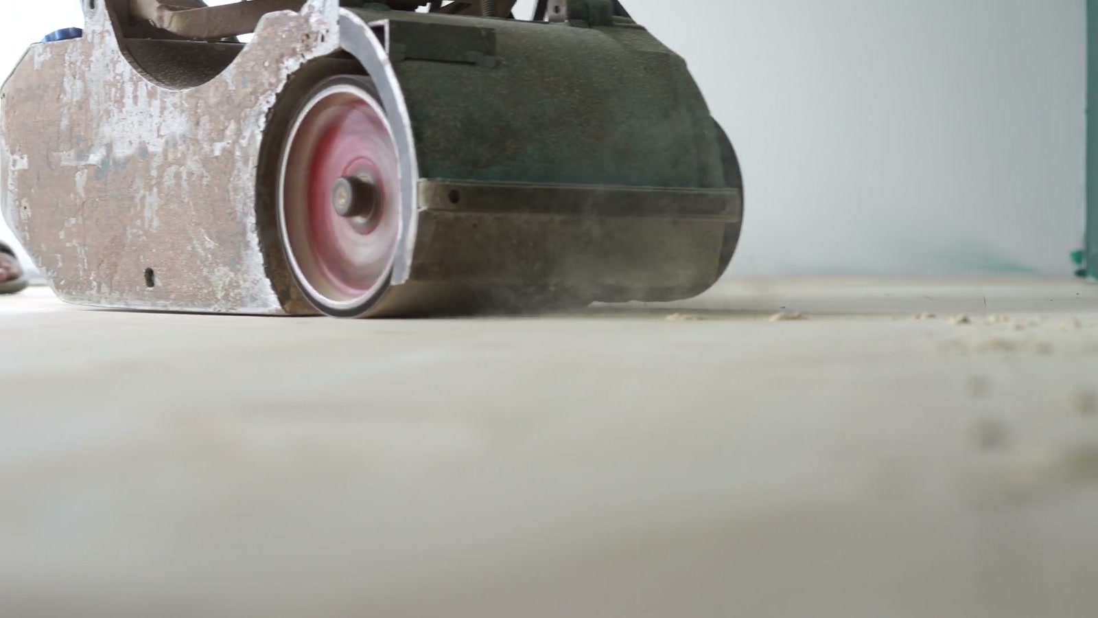 Close-up of a floor-sanding machine working on a wood floor